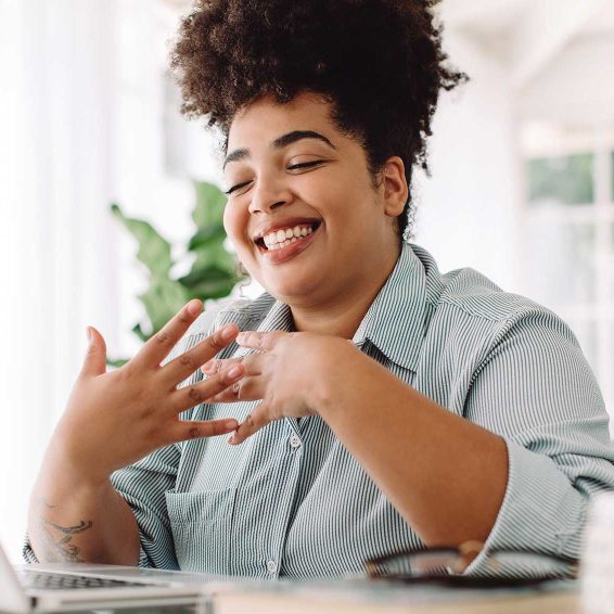 woman smiling in front of her laptop computer