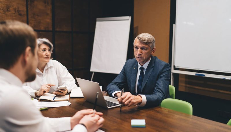 three people discussing business at a conference table