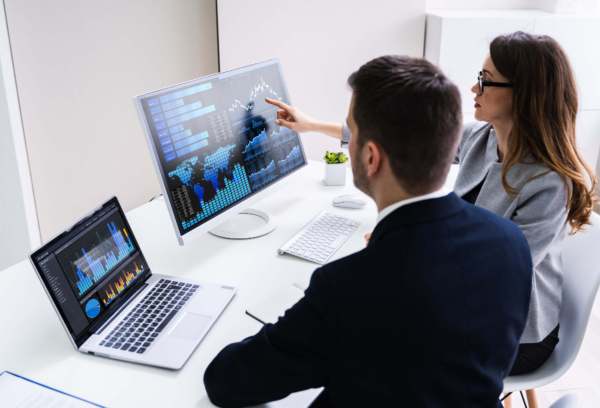 two people reviewing data visualizations on computer screen
