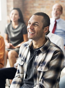 Image of a diverse group of people sitting in a room attending a conference meeting.